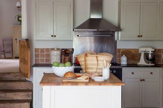Kitchen island and stainless steel cooking hood in a traditional kitchen