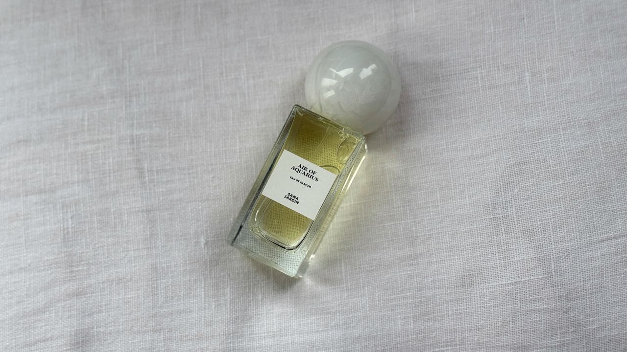 An image showing a bird&#039;s eye view of of the Sana Jardin Air of Aquarius perfume on a white linen background