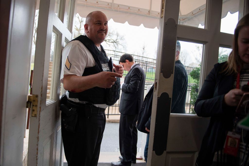 A security guard stands at the door of the White House press room.