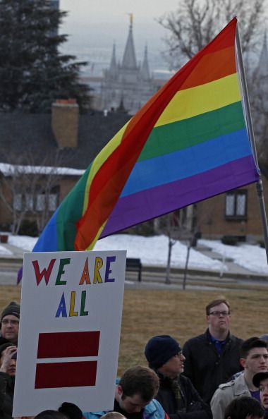 An LGBT flag in front of The Salt Lake Temple of the Church of Jesus Christ of Latter-Day Saints.