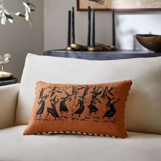 Halloween Dancing Witches Pillow Cover against a white sofa seat.