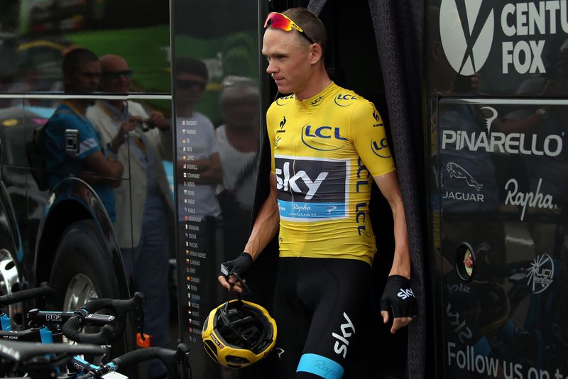 Chris Froome exits the bus to a large crowd of fans and media