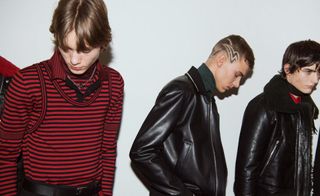 Group of models in black & red clothing looking down