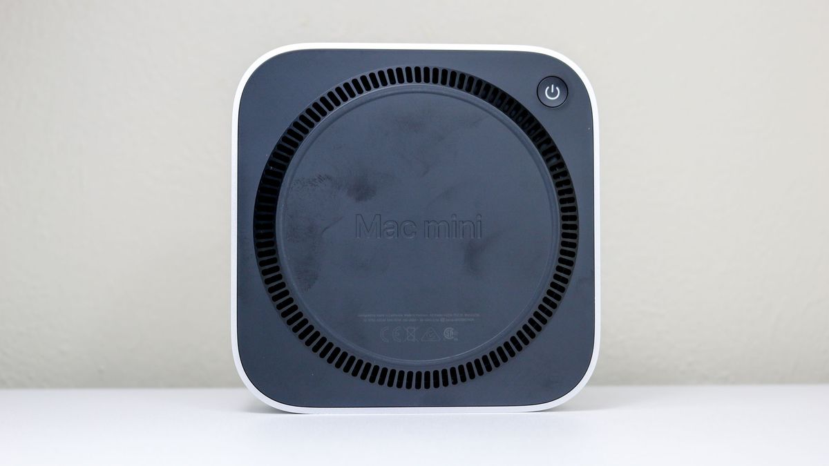 The Mac mini M4 upright on a desk showing its underside and power button