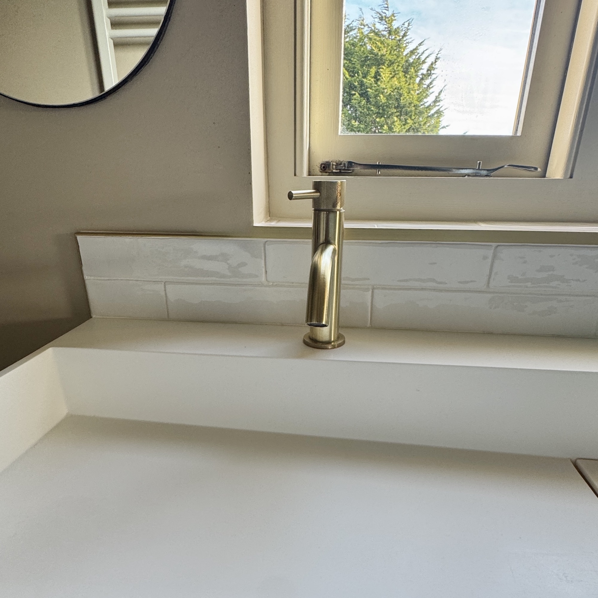 tiles with brass trim and white basin