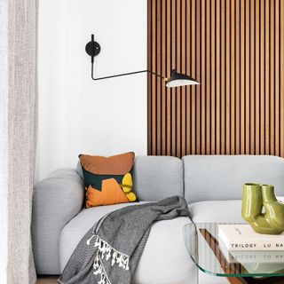 Living room with grey sofa in front of wooden wall panelling