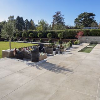 garden with patio with a sunken seating area, green lawn and manicured borders