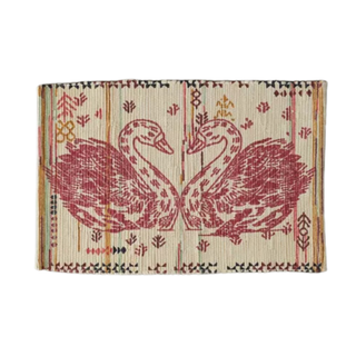 A boho screen printed rug with maroon swans
