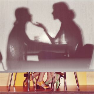 Guy Bourdin photograph of silhouette of woman behind screen with shoes showing
