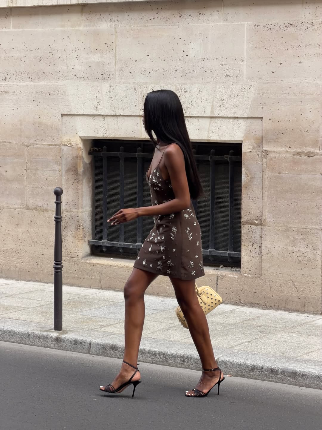 Liv wearing a brown mini dress and black heels