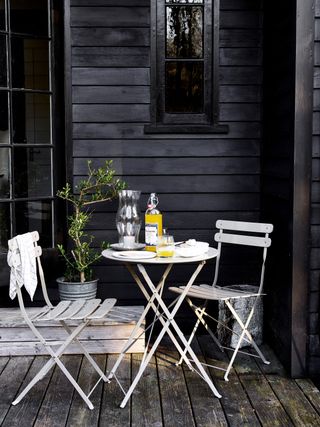 small bistro dining set on an outdoor decked terrace space