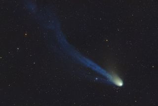 Devil Comet 12P/Pons-Brooks appears as a bright white and green comet with a long blue tail with a distinct kink in it.