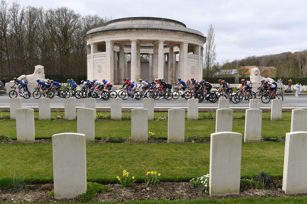 WEVELGEM BELGIUM MARCH 28 The Peloton passing through Flanders Fields Cemetery during the 83rd GentWevelgem in Flanders Fields 2021 Mens Elite a 254km race from Ypres to Wevelgem Landscape Graveyard GWE21 GWEmen FlandersClassic on March 28 2021 in Wevelgem Belgium Photo by Tim de WaeleGetty Images