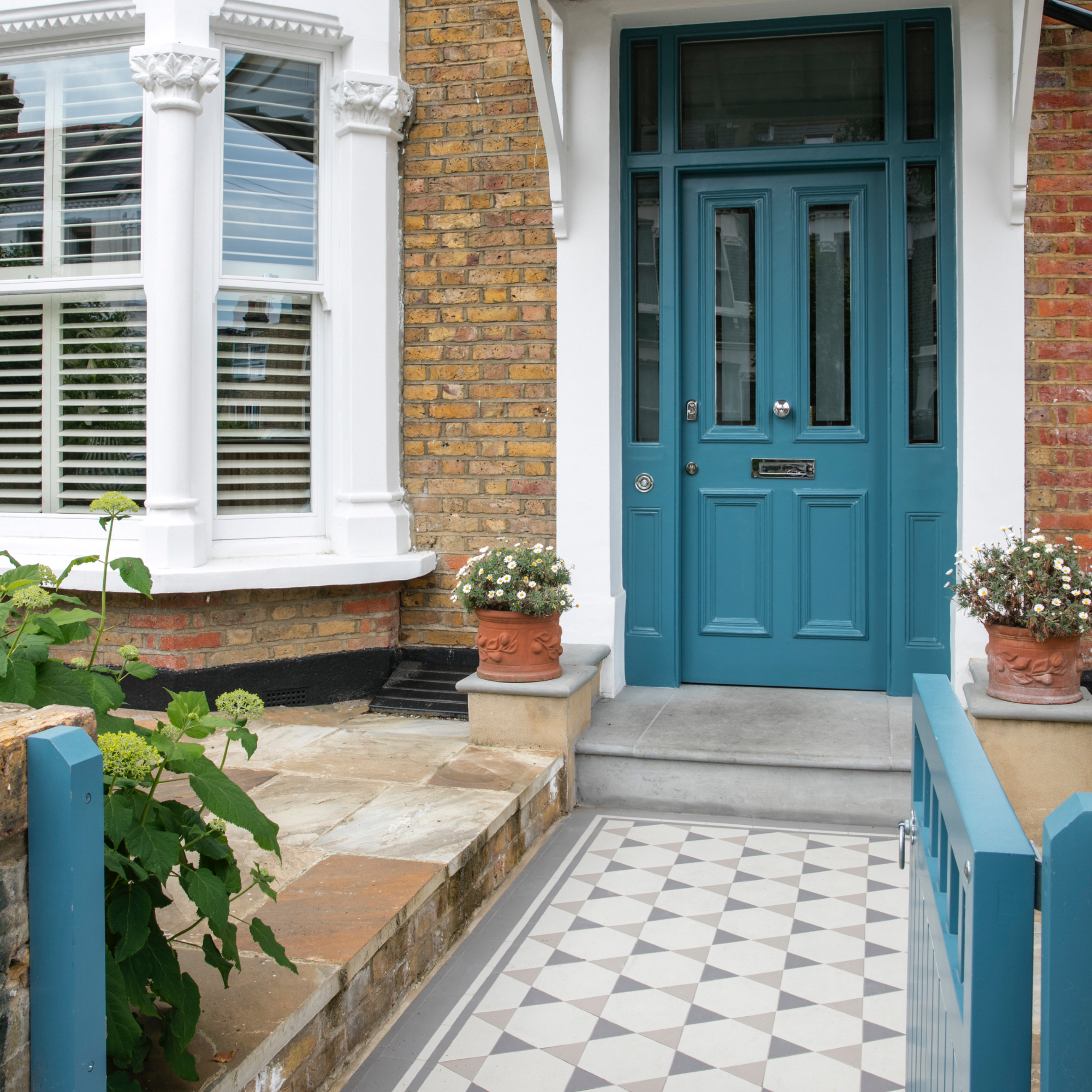 House with blue front door and gate, tiled pathway