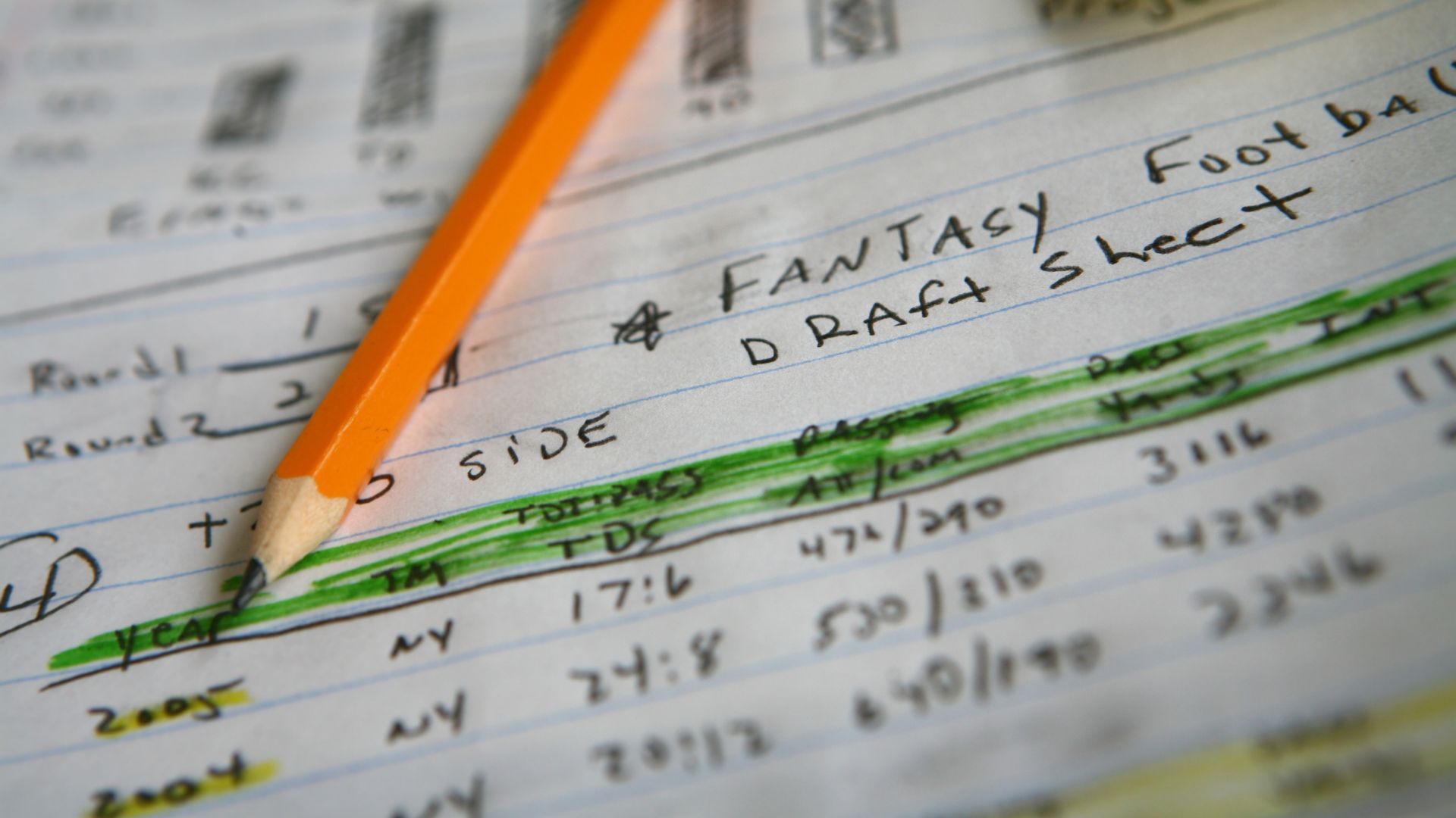 A pencil resting on a piece of paper plotting out drafts for fantasy football