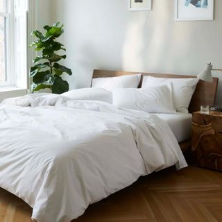 Brooklinen Classic Percale Core Sheet Set on a bed against a white wall.