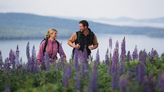 A couple hiking among purple wildflowers