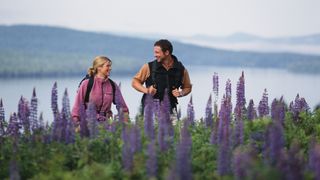 一对夫妇在紫色的野花中徒步旅行