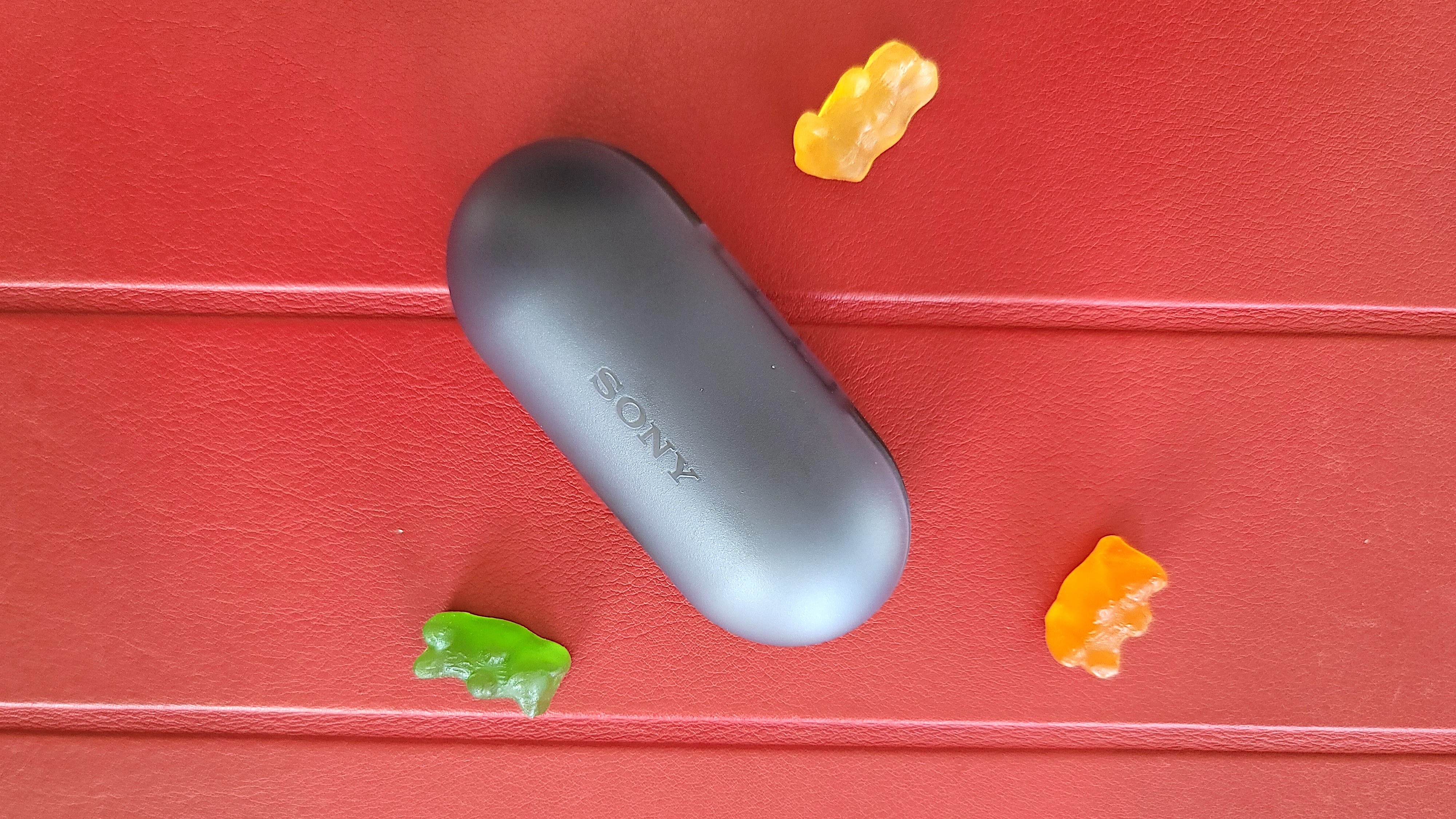 The Sony WF-C500 charging case surrounded by gummies