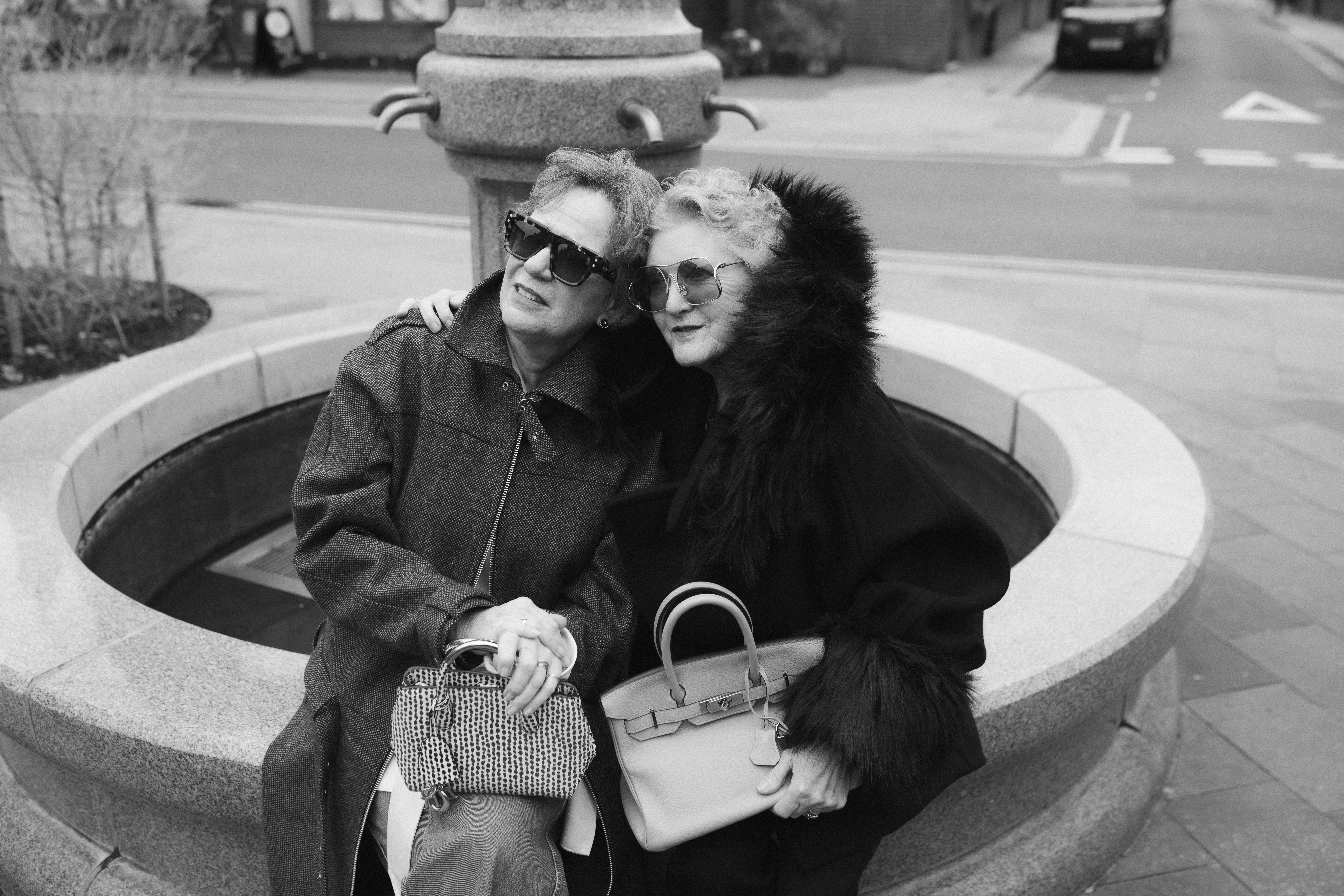 two women in london carrying designer bags