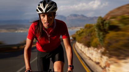 Woman road cycling up a hill
