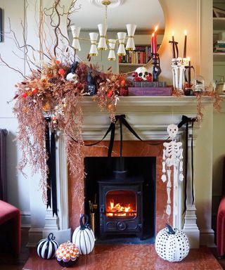 Halloween mantelpiece styled with halloween ornaments, black ribbon, dried flowers and old books