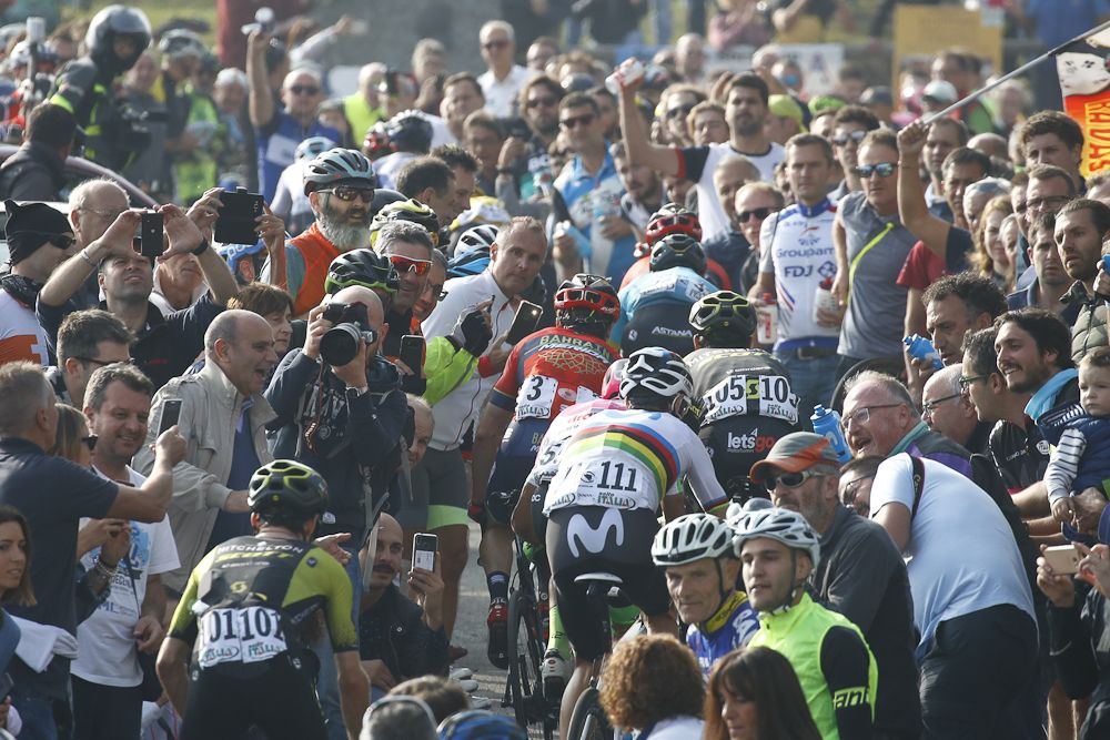 Alejandro Valverde climbs through the crowd at Il Lombardia
