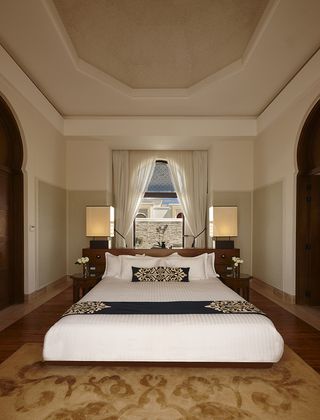 Bedroom in the Banyan Tree Tamouda Bay hotel with a large bed and wooden floors