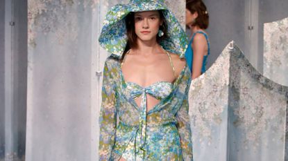Model wears bikini with matching hat and robe on the runway