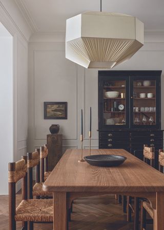 A neutral modern dining room with vintage accents and a large wooden dining table