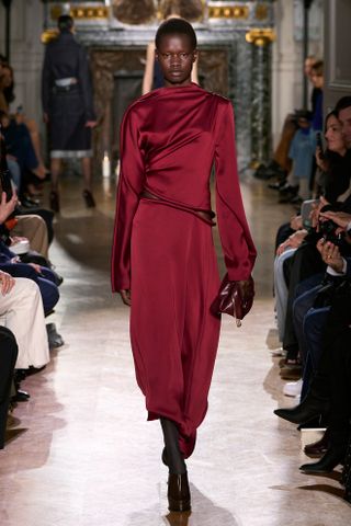 Woman in dark red satin dress on Victoria Beckham runway