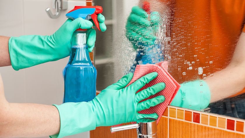 A person cleaning a mirror