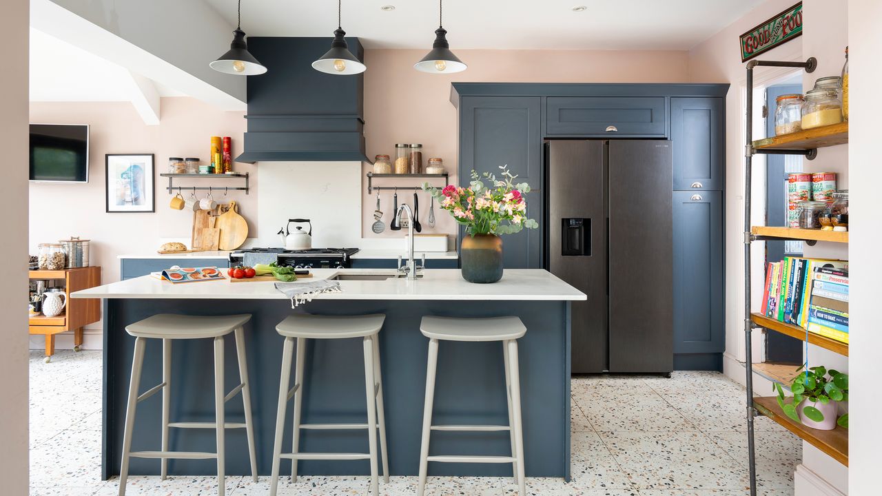 Pink and blue kitchen with island seating and sink