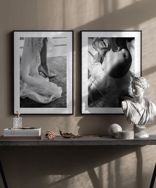 Black and white framed wall art above console in hallway area by Desenio