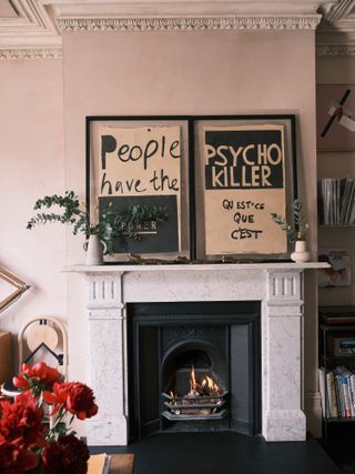 Pink living room with prints on the marble mantel
