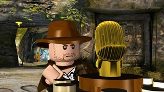 A screenshot from Lego Indiana Jones showing Indy about to swipe an ancient artefact.