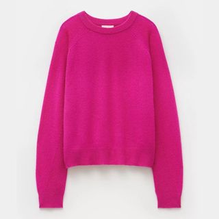 A cut out of a bright pink cashmere jumper on a white background