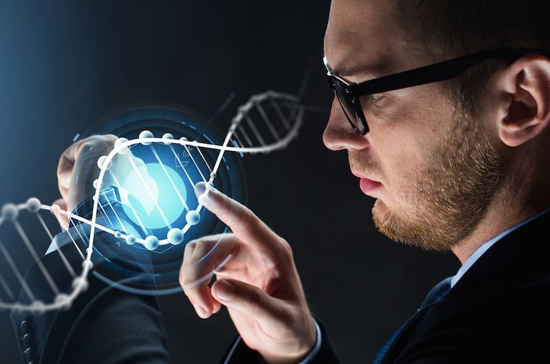 A man looks at a computer image of DNA.