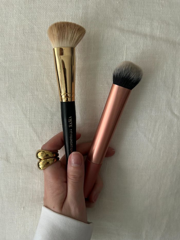 Junior beauty editor Grace Lindsay holding two foundation brushes