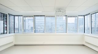 A completely white, empy room with panoramic windows on all sides.