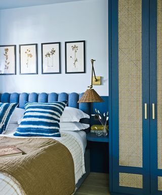 blue bedroom with double bed, artwork and rattan covered wardrobe
