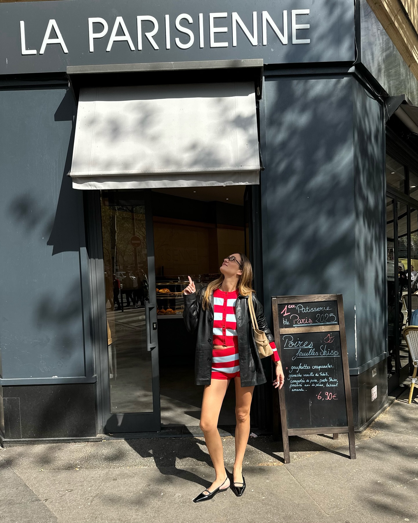 Anne wears a stripe top, stripe knit shorts, and a leather jacket with black leather flats.