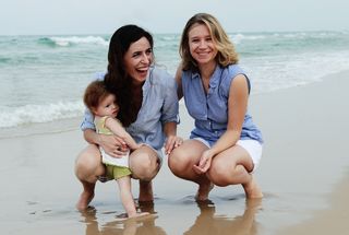 Lesbian couple and baby on beach