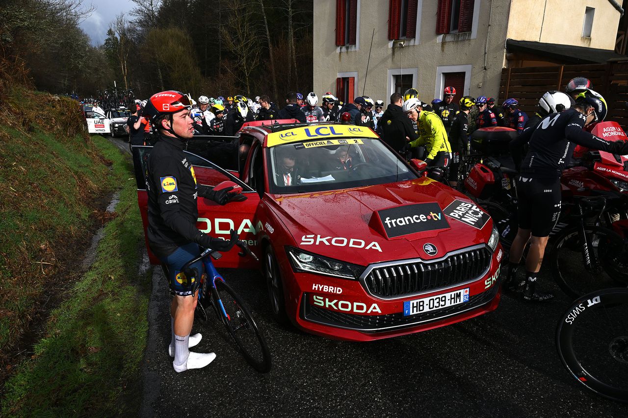 Riders gather around the lead race car after the neutralisation