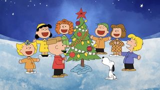 Charlie Brown, Snoopy and the gang gathered round a Christmas tree