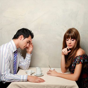 Couple sat at table ignoring each other