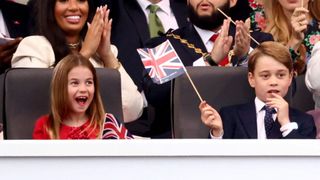 Princess Charlotte and Prince George of Cambridge cheer during the Platinum Party At The Palace at Buckingham Palace on June 4, 2022 in London, England
