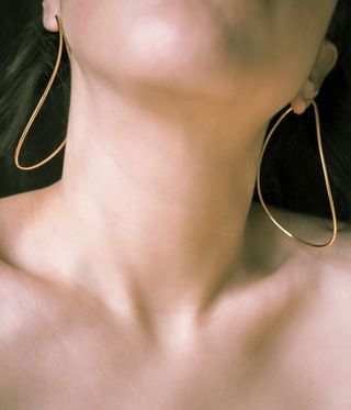 Woman wearing thin gold hoop earrings