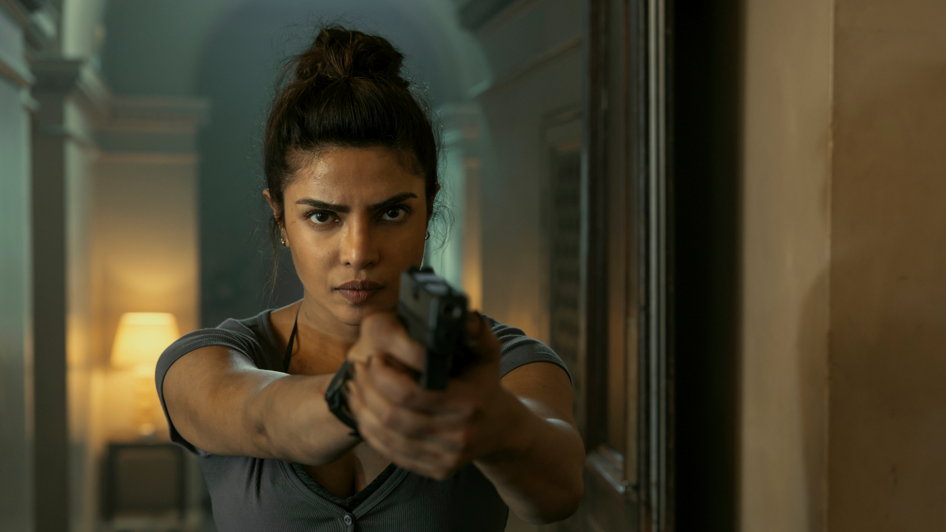 priyanka chopra points a gun down a hallway in the movie heads of state