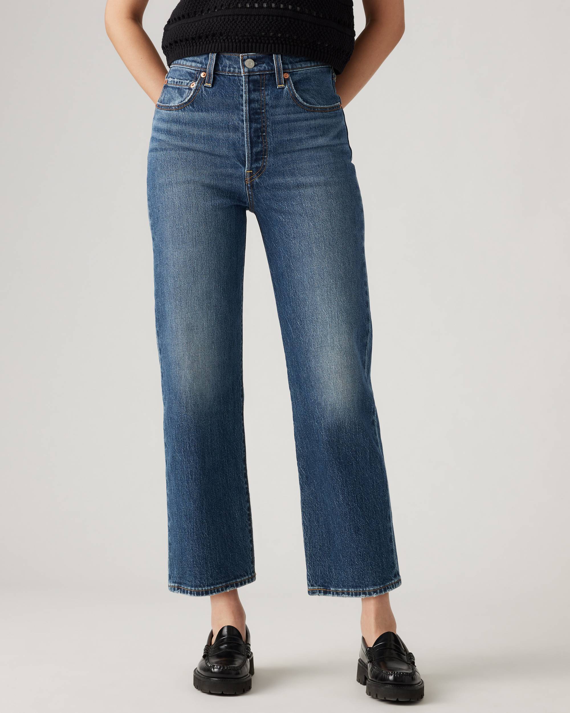 woman wearing blue jeans and black loafers